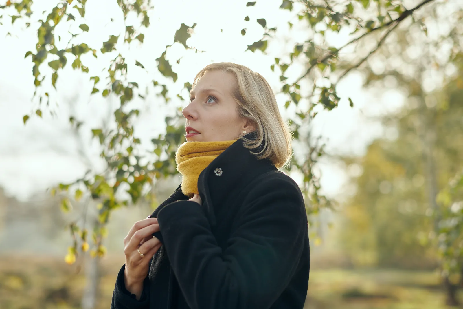 Hanna Zumsande mit gelbem Schal unter herbstlichen Blättern